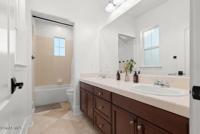 a bathroom with a tub sink and mirror