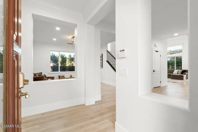 a view of a hallway with wooden floor windows and livingroom