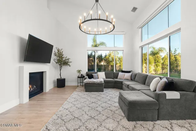 a living room with furniture a chandelier and a fireplace