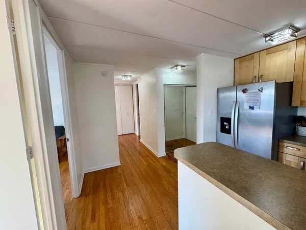 a kitchen with stainless steel appliances a stove a sink a refrigerator cabinets and a window