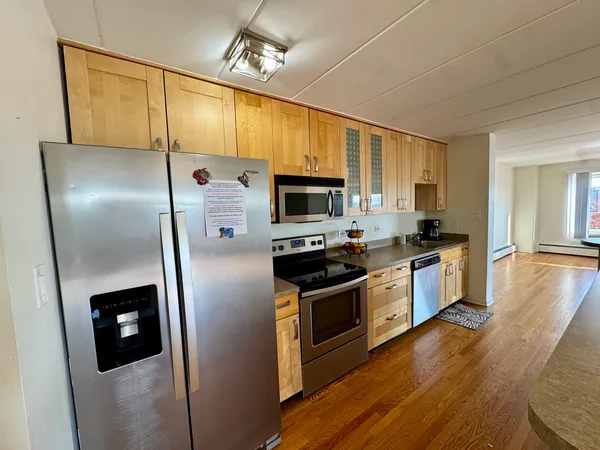 a kitchen with kitchen island stainless steel appliances a sink stove top oven and cabinets