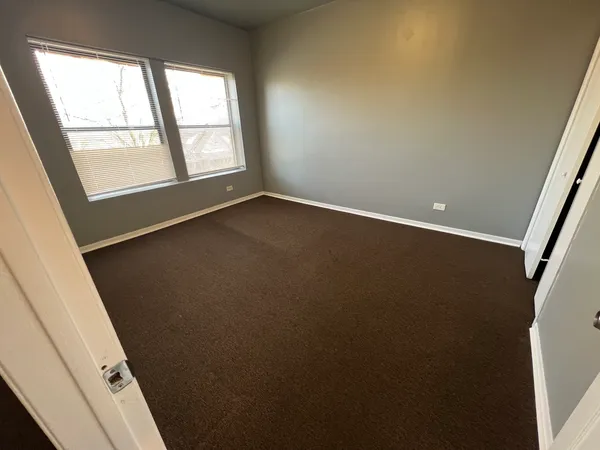 an empty room with windows and closet