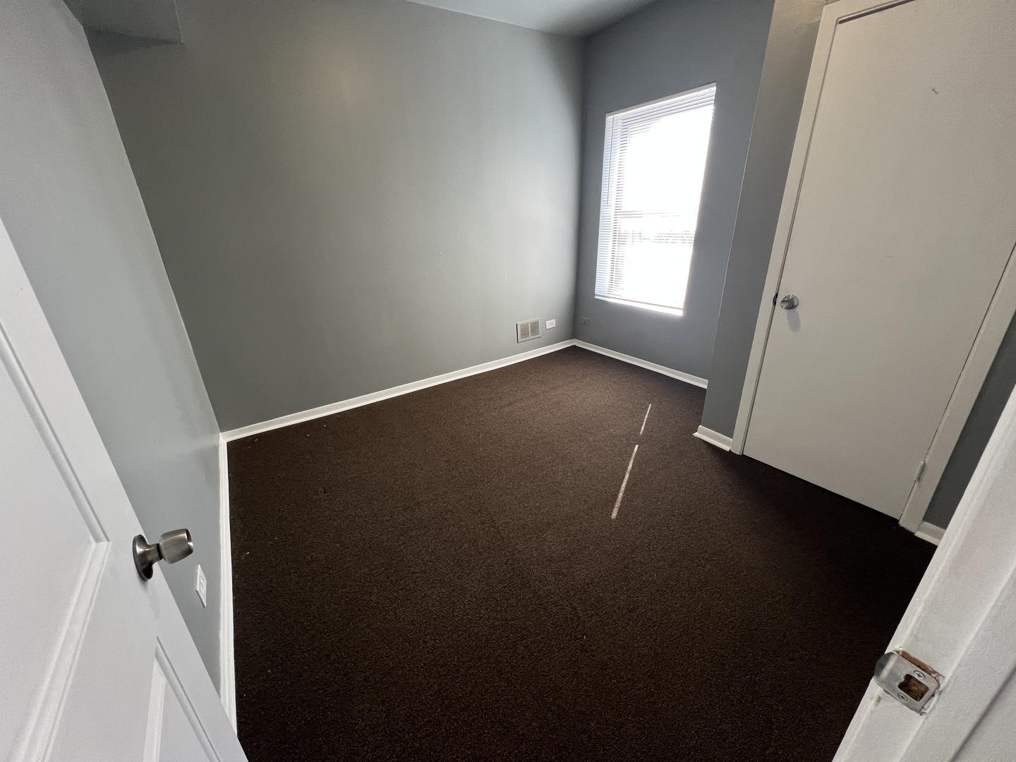 6902 South Michigan Avenue, Unit 3S Chicago, IL 60637 - Photo 4 of 8 an empty room with wooden floor and windows