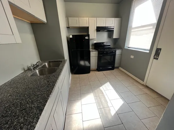 a kitchen with granite countertop a refrigerator and a stove