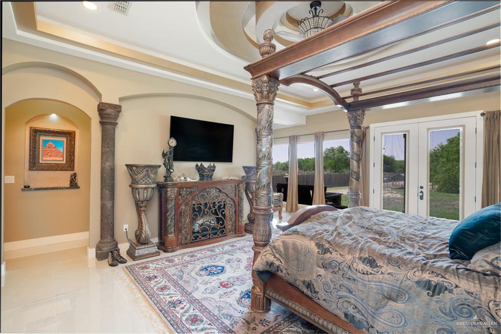 1627 South Midway Road Donna, TX 78537 - Photo 12 of 36 a bedroom with a bed a flat screen tv and a large window with the garden view