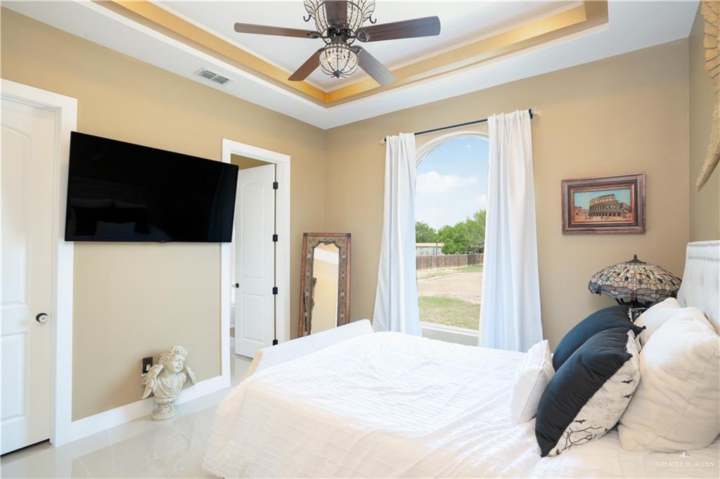 1627 South Midway Road Donna, TX 78537 - Photo 15 of 36 a bedroom with a bed and a flat tv screen