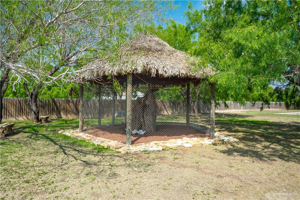 1627 South Midway Road Donna, TX 78537 - Photo 21 of 36 a backyard of a house with table and chairs under an umbrella