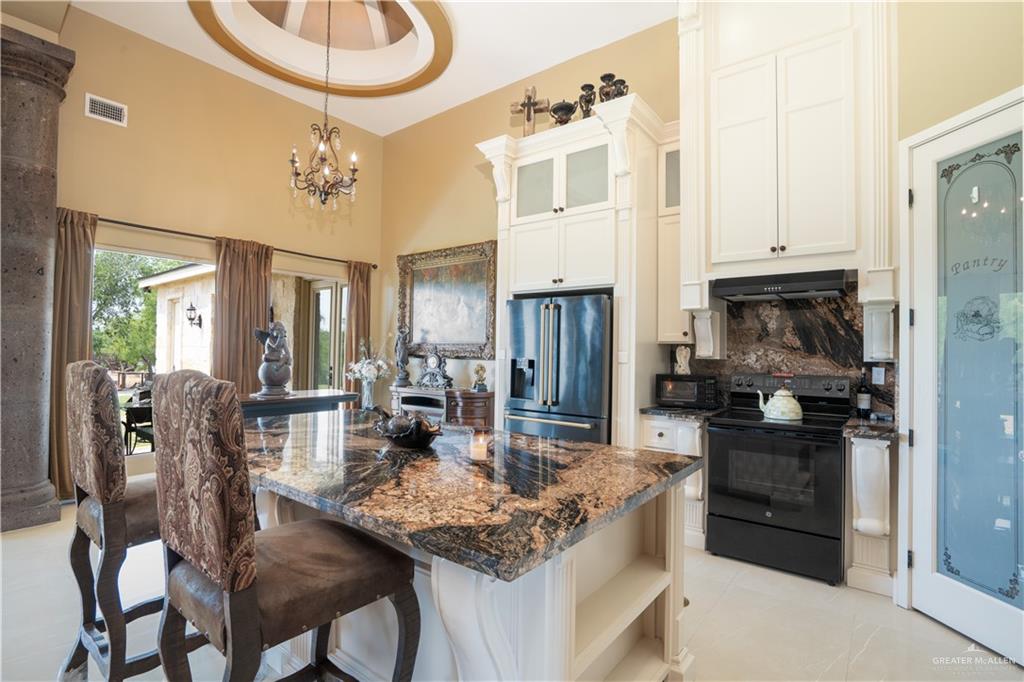1627 South Midway Road Donna, TX 78537 - Photo 9 of 36 a kitchen with stainless steel appliances granite countertop a stove refrigerator and cabinets