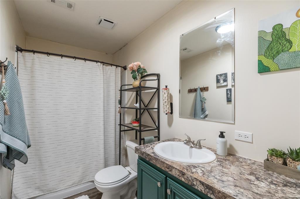 308 Marion Street Merkel, TX 79536 - Photo 11 of 20 a bathroom with a granite countertop toilet sink and mirror