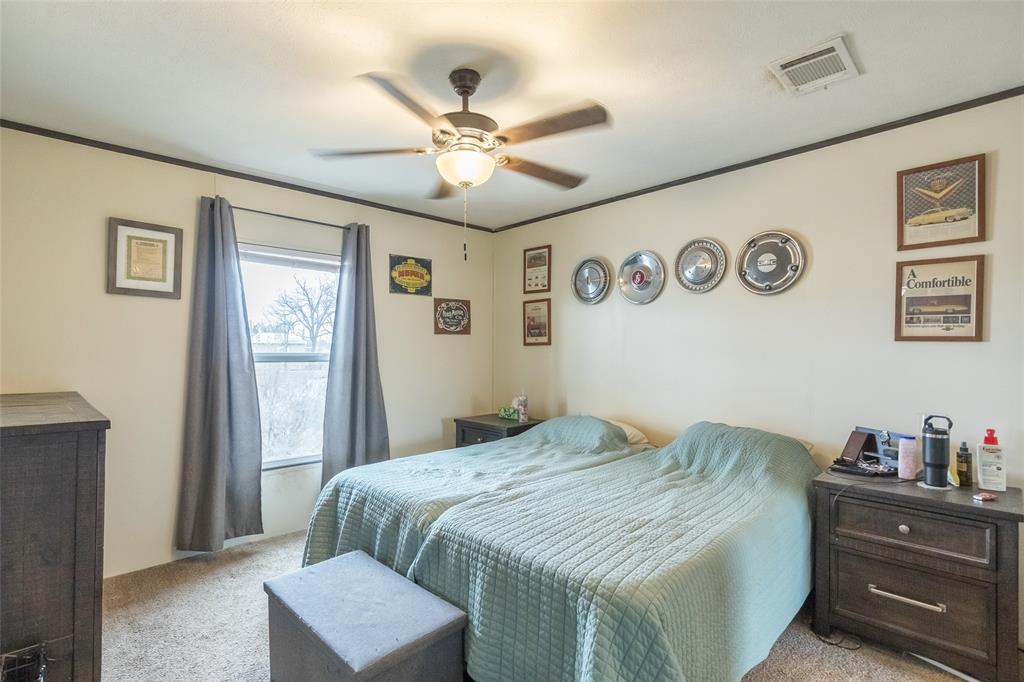 308 Marion Street Merkel, TX 79536 - Photo 13 of 20 a bedroom with a large bed and a chandelier