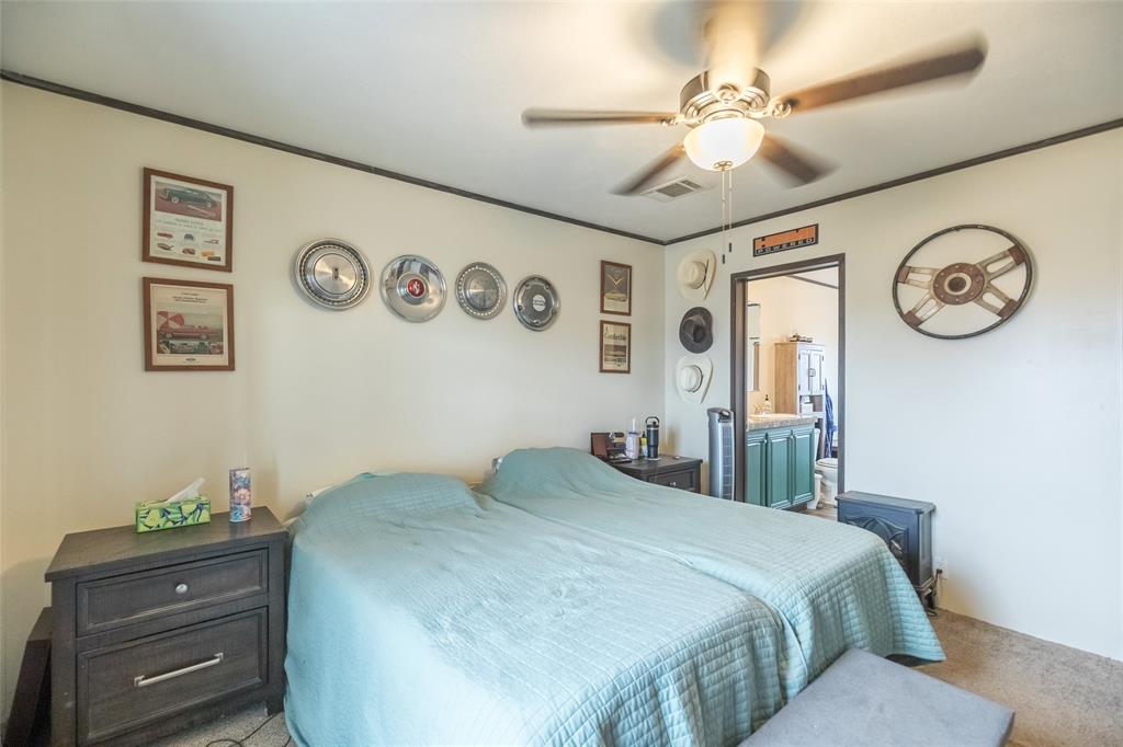 308 Marion Street Merkel, TX 79536 - Photo 14 of 20 a bedroom with a bed and a chandelier