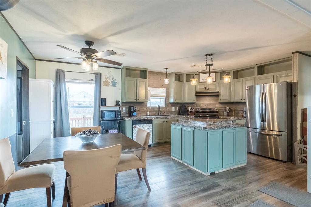 308 Marion Street Merkel, TX 79536 - Photo 3 of 20 a kitchen with granite countertop a refrigerator a stove a sink dishwasher a dining table and chairs with wooden floor
