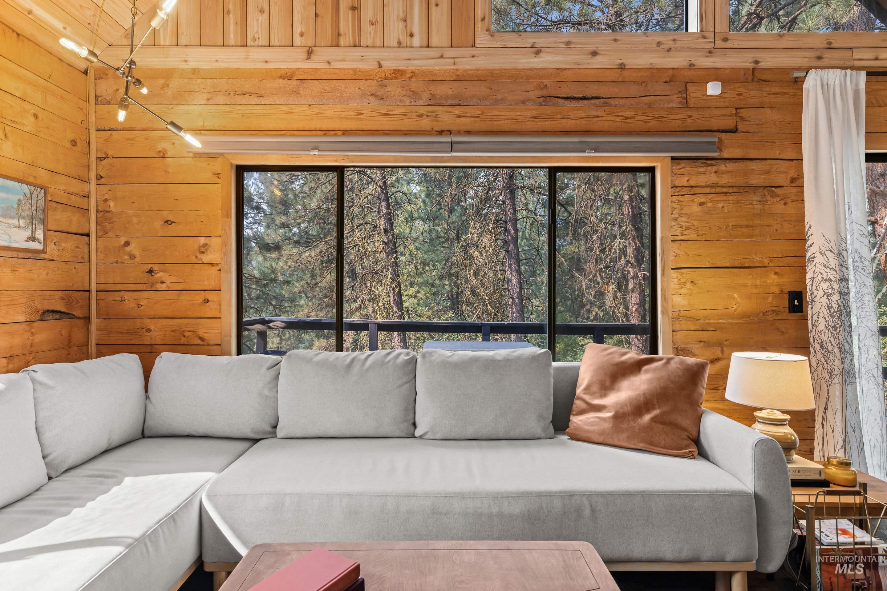 73 Rainbow Ridge Road Garden Valley, ID 83622 - Photo 28 of 49 Wood-paneled walls, exposed wood beam, clerestory windows, multi-paned windows, and a multi-arm ceiling fixture