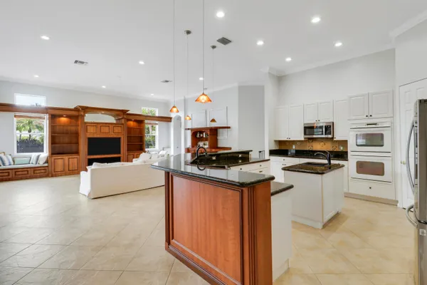 a kitchen with granite countertop a sink a stove and refrigerator