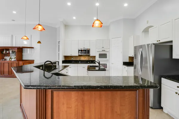 a kitchen with stainless steel appliances granite countertop a sink and a stove