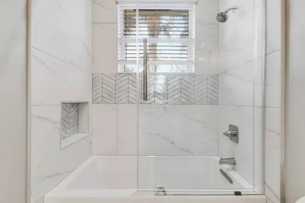a bathroom with a tub sink and mirror