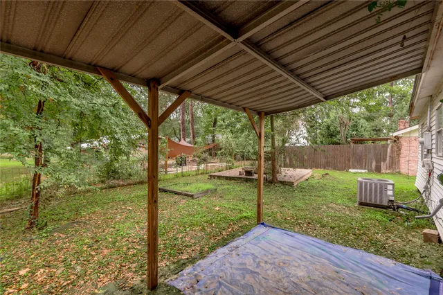 a view of a backyard with table and chairs under an umbrella with a small yard