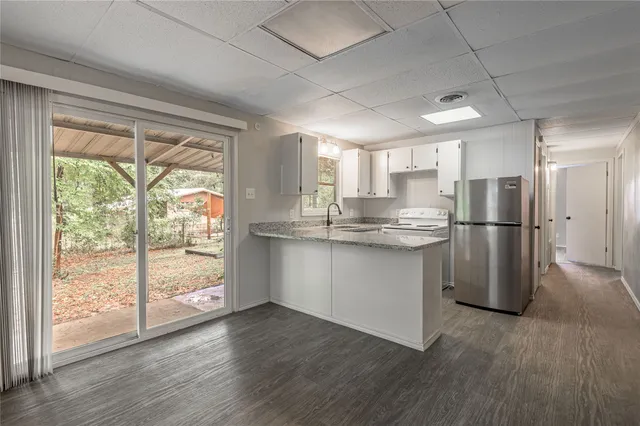 a kitchen with a refrigerator and wooden floor