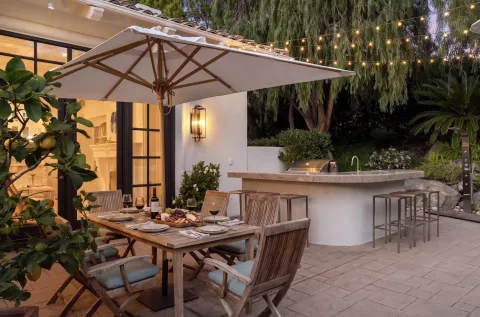 a view of a patio with table and chairs under an umbrella