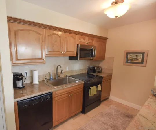 a kitchen with stainless steel appliances granite countertop a sink stove and microwave
