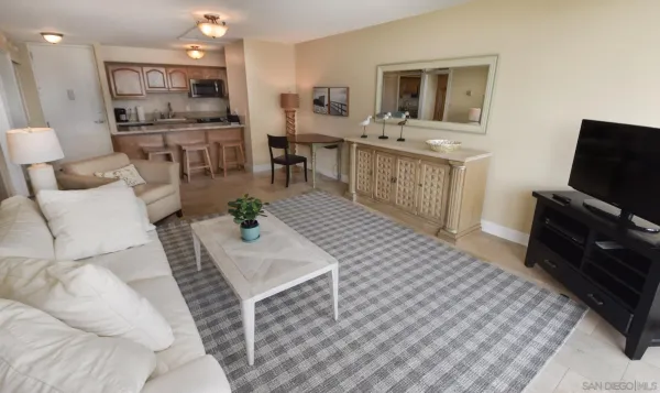 a living room with furniture a flat screen tv and kitchen view