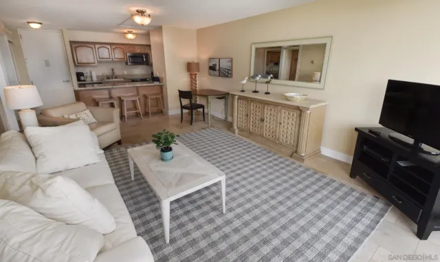 a living room with furniture a flat screen tv and kitchen view