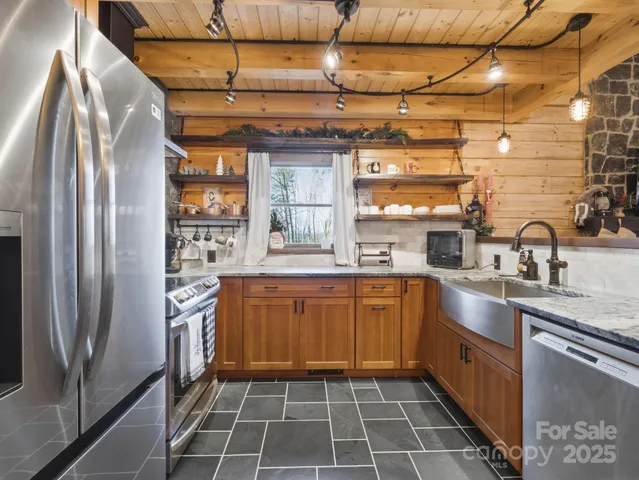 a large kitchen with stainless steel appliances granite countertop a refrigerator and a sink