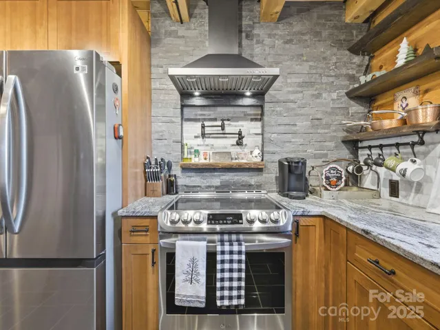 a kitchen with stainless steel appliances granite countertop a stove and a refrigerator