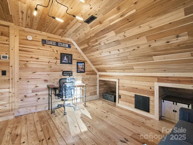 a view of a livingroom with wooden floor and a fireplace