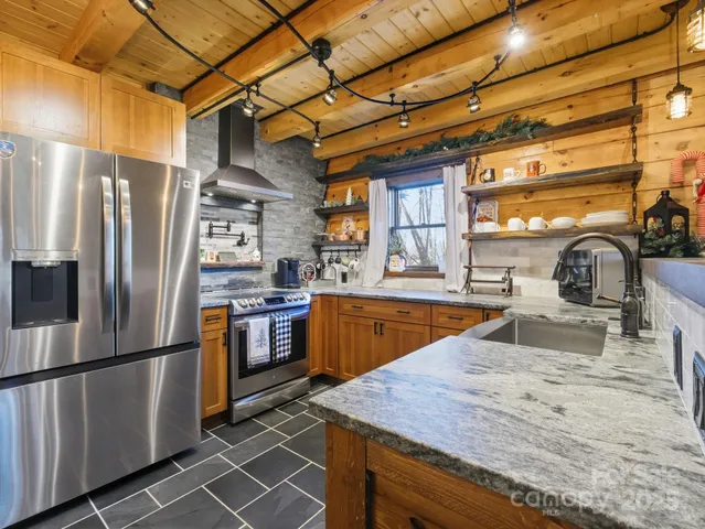 a kitchen with stainless steel appliances granite countertop a refrigerator and a sink