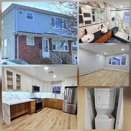 a front view of a house with stairs and a large tree