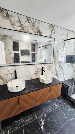 a bathroom with a sink mirror and shower