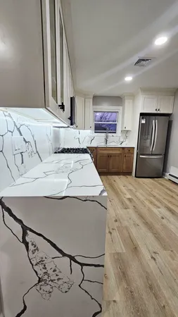 a kitchen with stainless steel appliances a stove a microwave and white cabinets