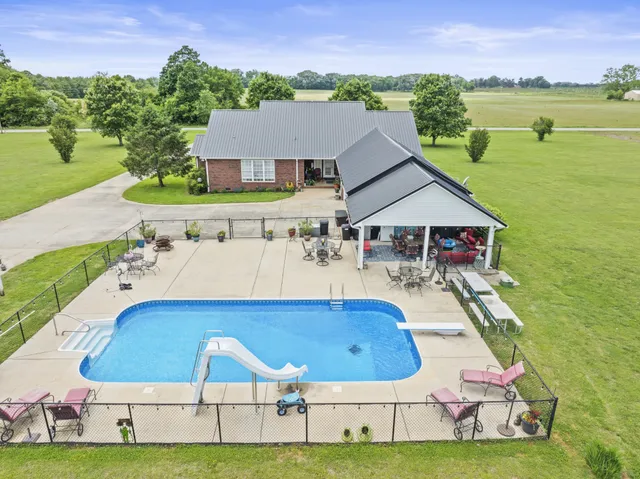 a aerial view of a house with swimming pool and a yard
