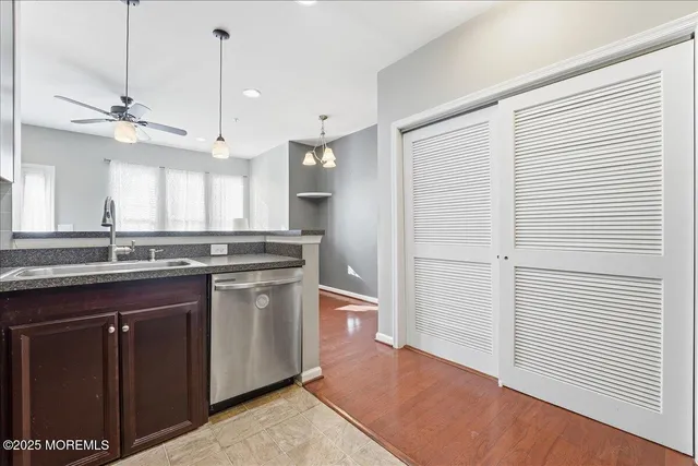 a kitchen with stainless steel appliances granite countertop a sink a counter space and a window
