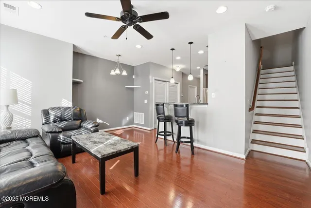 a living room with furniture and a wooden floor