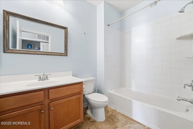 a bathroom with a granite countertop sink toilet a mirror and shower