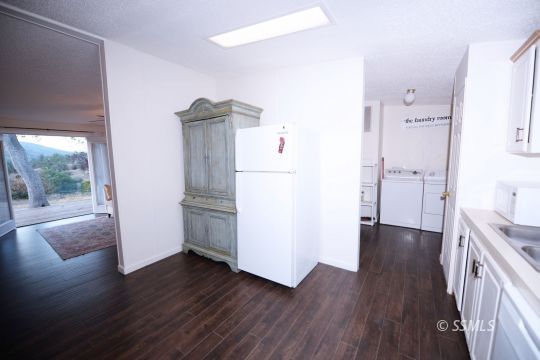 208 Charity Road Caliente, CA 93518 - Photo 9 of 47 an empty room with wooden floor and a kitchen