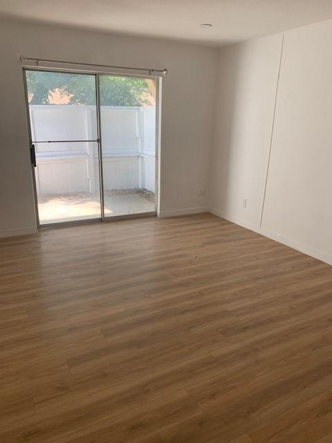 5721 Harvest Hill Road, Unit 1036 Dallas, TX 75230 - Photo 3 of 9 an empty room with wooden floor and door