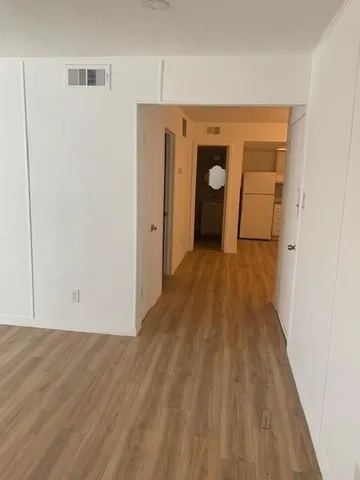 a view of a hallway with wooden floor