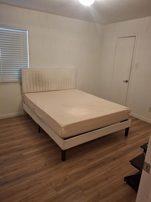 5721 Harvest Hill Road, Unit 1036 Dallas, TX 75230 - Photo 7 of 9 a bed sitting in a room next to a window