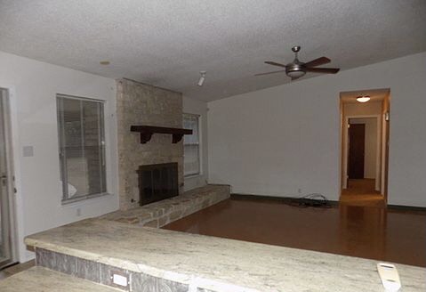 509 Meadowbrook Drive Georgetown, TX 78628 - Photo 10 of 17 A spacious living area with a cozy stone fireplace, offering an inviting atmosphere.