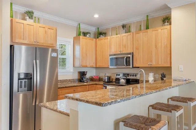 a kitchen with stainless steel appliances granite countertop a refrigerator a sink a stove a microwave and island