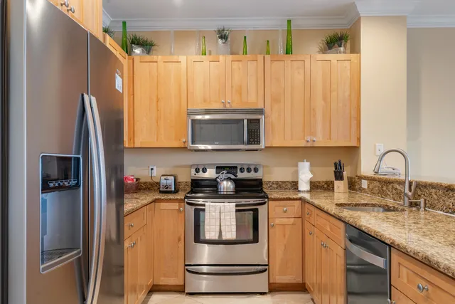 a kitchen with granite countertop a refrigerator stove and microwave