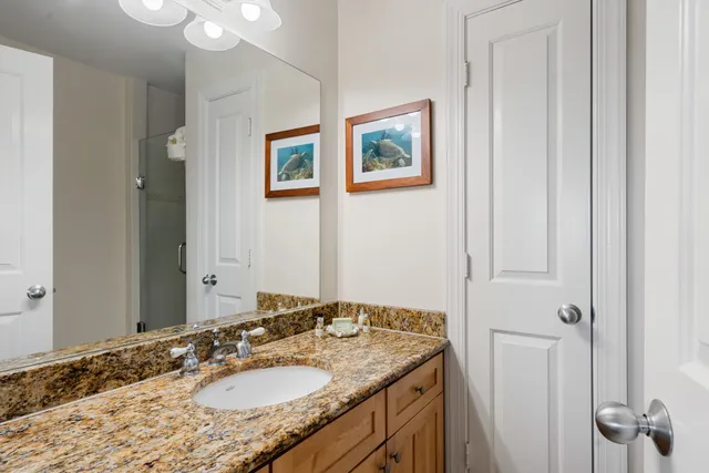 a bathroom with a granite countertop sink and a mirror