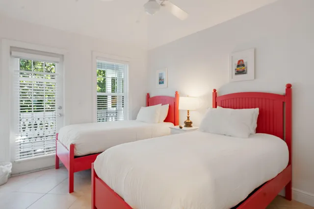 a bedroom with two bed and a large window
