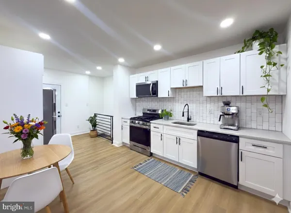 a kitchen with stainless steel appliances granite countertop a stove refrigerator sink and cabinets