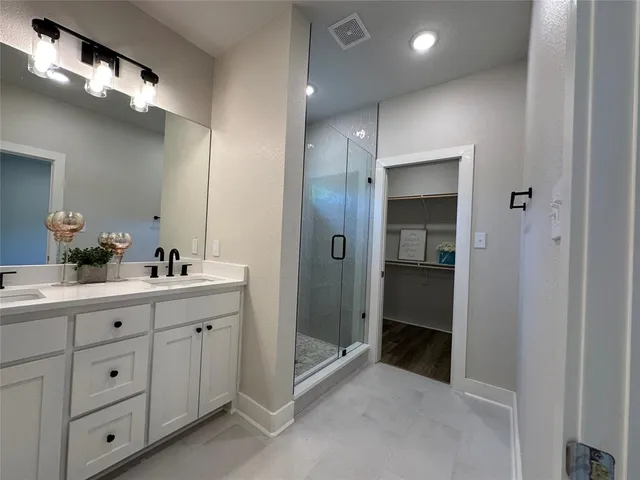 a bathroom with a double vanity sink and mirror
