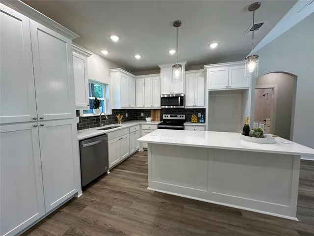 a kitchen with kitchen island white cabinets and white appliances