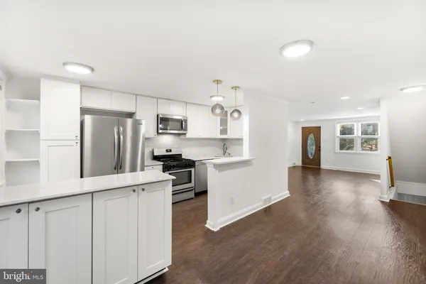 a kitchen with stainless steel appliances a refrigerator and a stove top oven